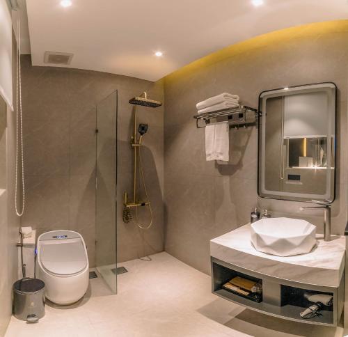 a bathroom with a toilet and a sink and a shower at New Century Dalat Hotel in Da Lat