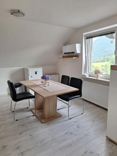 a dining room table with two chairs and a window at Apartma Saint Thomas in Selca