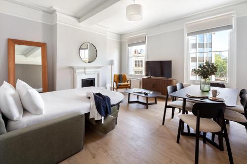a bedroom with a large bed and a living room at Marlin Westminster Apartments in London