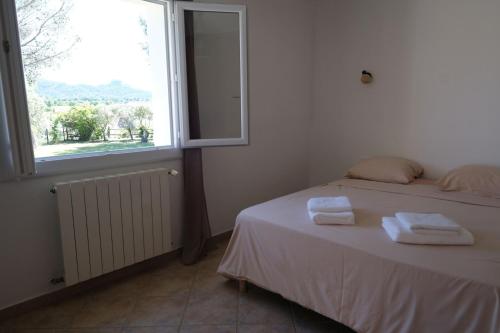 une chambre avec un lit avec deux serviettes dessus dans l'établissement Villa overlooking the Alpilles Saint Remy de Provence LS1-454, à Saint-Rémy-de-Provence