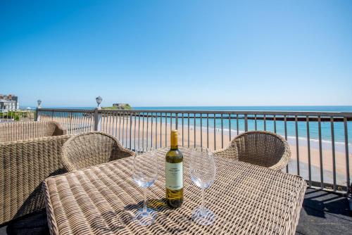 a bottle of wine sitting on a table next to the beach at Imperial Hotel Tenby in Tenby