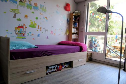 - une chambre avec un lit doté de draps violets et une fenêtre dans l'établissement Beau 4 pièces dans coin de verdure, à Paris