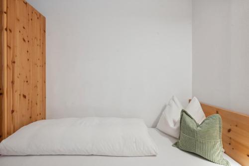 a bedroom with a bed with white sheets and pillows at Prackfolerhof in Fie allo Sciliar