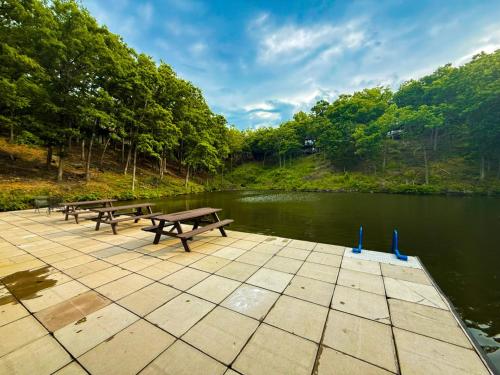 two picnic tables on a pier next to a river at Treetop Village51-3bed3bapools-8pp in Four Seasons