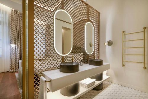 a bathroom with two sinks and a mirror at Grand Hotel Centenari, Valencia, Autograph Collection in Valencia