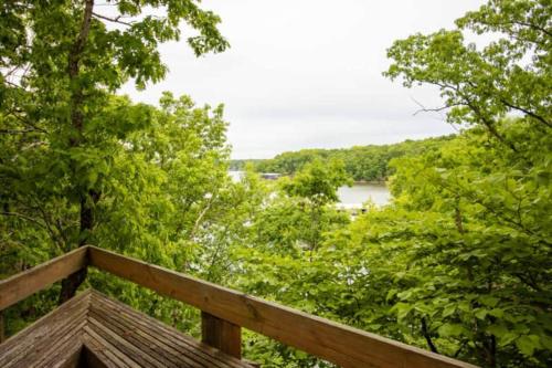 a wooden deck with a view of a river and trees at Treetop Village-3bed3bathpoolsdock8pp in Four Seasons