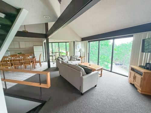 a living room with a couch and a table at Treetop Village-3bed3bathpoolsdock8pp in Four Seasons