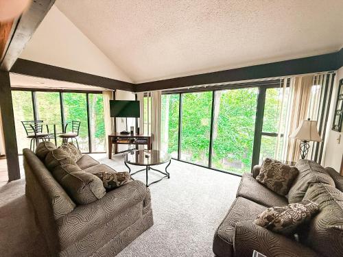a living room with two couches and a table at Treehouse Treetop Vllage57-3bed3bapools-8pp in Four Seasons