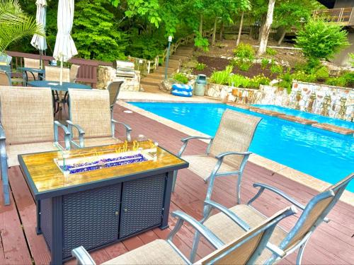 a table and chairs next to a swimming pool at Treetop 3bd3badeckpoolsgrilldock-sleeps 8pp in Four Seasons