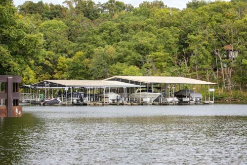 a house on the water next to a lake at Treetop 3bd3badeckpoolsgrilldock-sleeps 8pp in Four Seasons