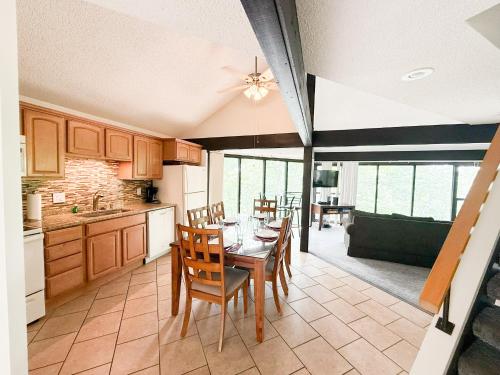a kitchen with a table and chairs in a room at Treetop 3bd3badeckpoolsgrilldock-sleeps 8pp in Four Seasons
