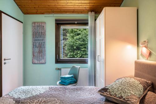 a bedroom with a bed and a window and a chair at Ferienhaus Sweet Home in Ronshausen