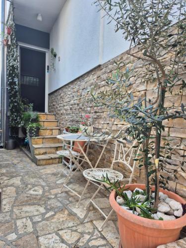 a patio with a table and chairs next to a brick wall at Apartments Valentina Tisno in Tisno