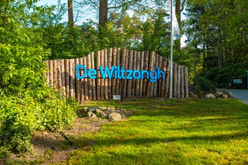 a wooden fence with the sign for be willbuquerque at Vakantiepark De Wiltzangh in Ruinen