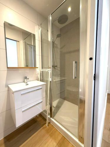 une salle de bain blanche avec une douche et un lavabo dans l'établissement M11 Marquer Studio le Clos Fleury, à Annemasse