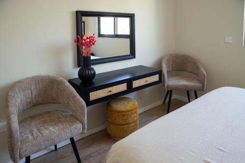 a bedroom with a desk with two chairs and a mirror at Maison Noire by Staycom in Strovolos