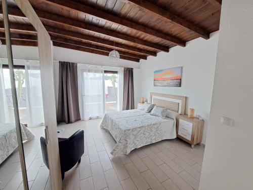 een slaapkamer met een bed en een houten plafond bij Bella Blanca in Playa Blanca