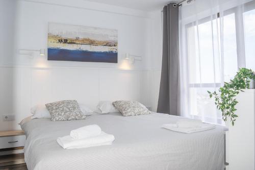 ein Schlafzimmer mit einem weißen Bett mit zwei Handtüchern darauf in der Unterkunft Ocean House Costa del Sol apartamentos varios by Costa del Sol Stay in Torremolinos