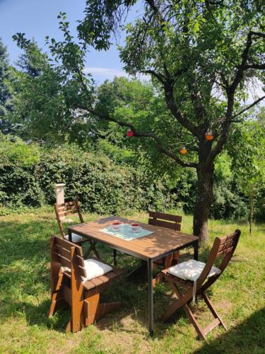a wooden table and chairs under a tree at Healing Garden Leányfalu in Leányfalu