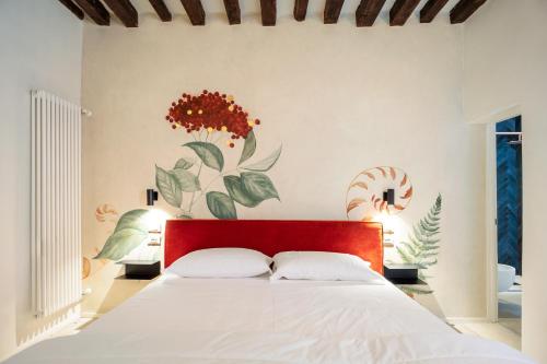 a bedroom with a white bed with a red headboard at QN Apartments in Venice
