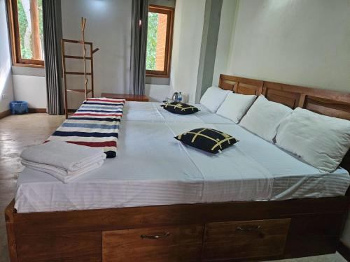 a large bed with two pillows on top of it at THE HIDEOUT KURUNEGALA in Kurunegala