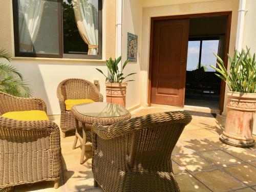 a patio with wicker chairs and a table and chairs at Villa Panorama - Stunning views in villa with hot tub, pool, garden in Kouklia