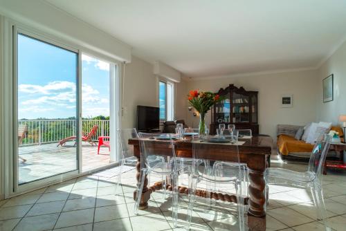 un salon avec une table et des chaises et un balcon dans l'établissement Ty-Ruz - Maison familiale proche plages Billiers, à Billiers