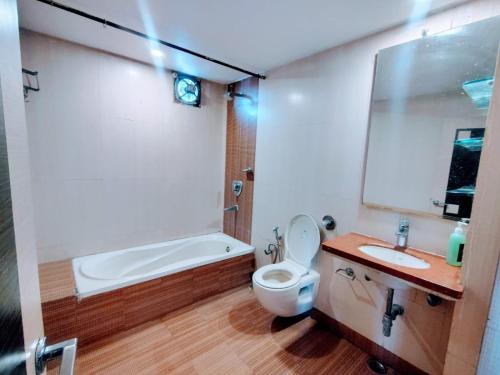 a bathroom with a tub and a toilet and a sink at Hotel Apex Intercontinental in Jaipur