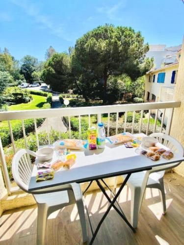 - une table sur un balcon avec de la nourriture dans l'établissement Bright apartment for 4 - near beach, à Saint-Raphaël