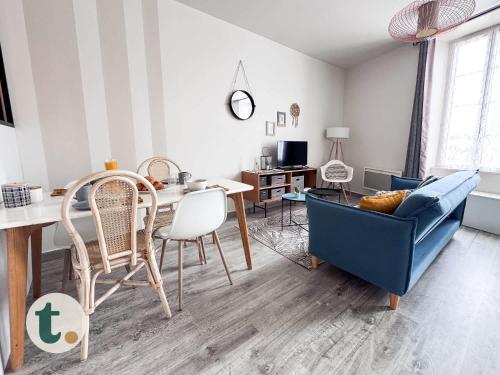 un salon avec un canapé bleu et une table dans l'établissement Tranquiloue - Studio Plein Centre - Puy du Fou 20min, aux Herbiers