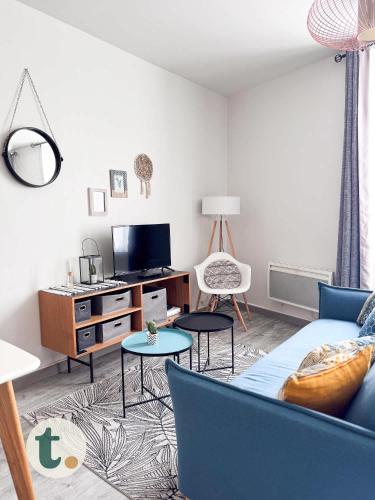 un salon avec un canapé bleu et une télévision dans l'établissement Tranquiloue - Studio Plein Centre - Puy du Fou 20min, aux Herbiers
