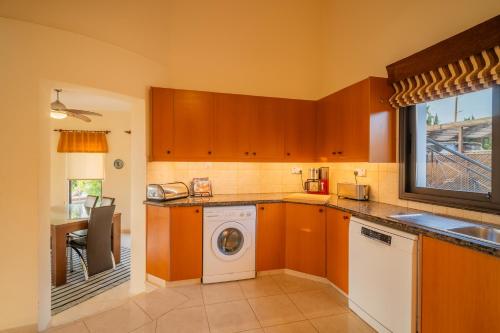 a kitchen with a washer and a washing machine at Villa Panorama - Stunning views in villa with hot tub, pool, garden in Kouklia
