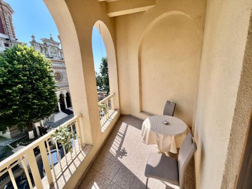 a balcony of a building with a table and chairs at Catedrala Blue in Constanţa