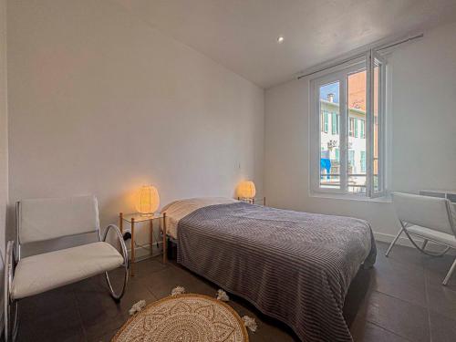 une chambre avec un lit et deux chaises et une fenêtre dans l'établissement Urban Chic - 3 pers, Wifi, Parking, à Nice