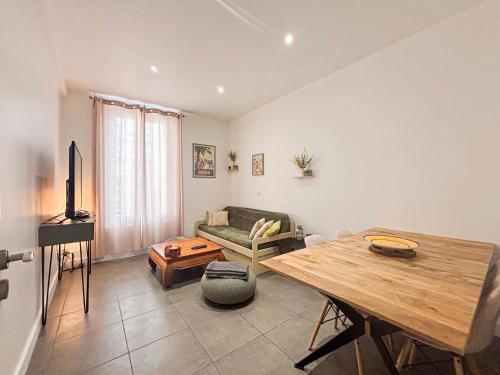 un salon avec une table et un canapé dans l'établissement Urban Chic - 3 pers, Wifi, Parking, à Nice