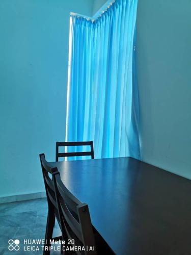 a table with two chairs and a blue curtain at PD WORLD MARINa in Port Dickson
