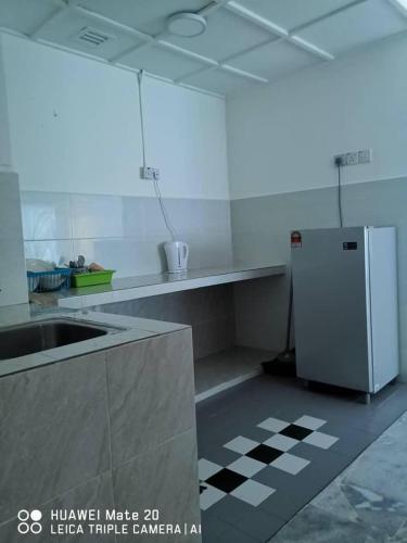 a white kitchen with a sink and a refrigerator at PD WORLD MARINa in Port Dickson
