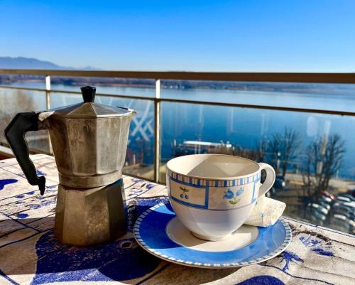 a coffee maker and a cup on a table with a view at Gemelli al Lago in Arona