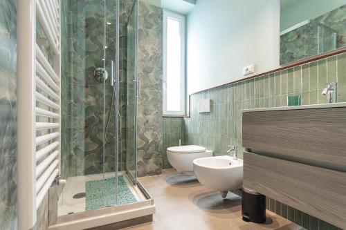 Un baño con inodoro y ducha de cristal. en Fronte Castello - Centro Città, en Génova