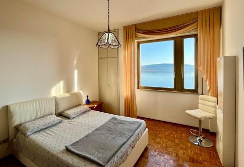 a bedroom with a bed and a large window at Gemelli al Lago in Arona
