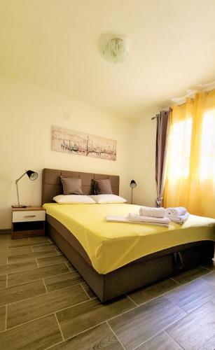 a bedroom with a large bed with yellow sheets at Apartment MMP in Kotor
