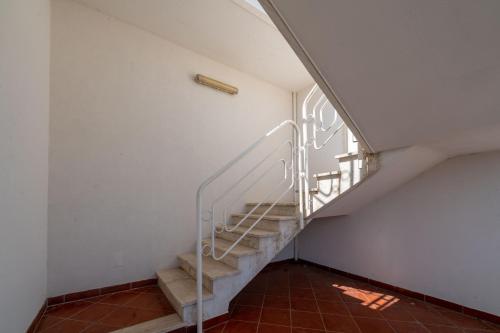 a staircase in a house with a metal railing at Casa Chanty in Villanova di Ostuni