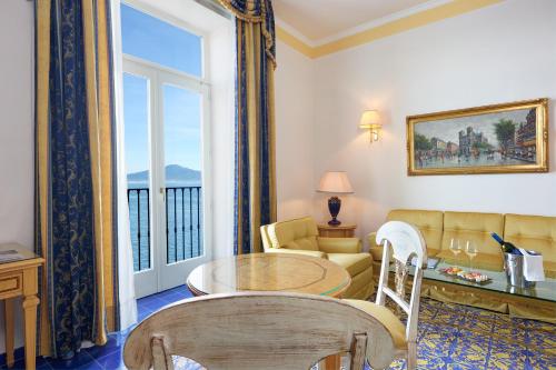 a living room with a table and a large window at Imperial Hotel Tramontano in Sorrento