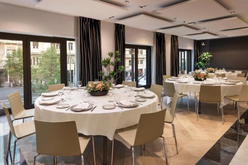 a large dining room with white tables and chairs at Catalonia Plaza España Hotel & Spa in Madrid