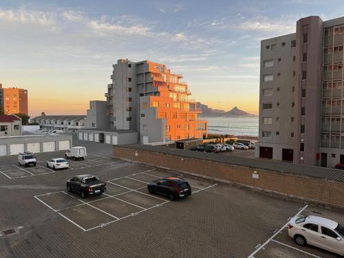 a parking lot with cars parked in a parking lot at SeeHUYS Boutique Bloubergstrand Beachfront Studio in Cape Town