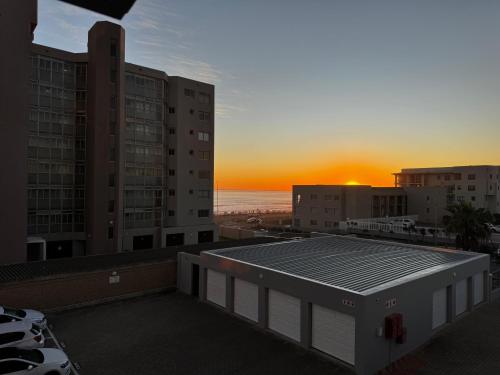 a view of the sunset from the roof of a building at SeeHUYS Boutique Bloubergstrand Beachfront Studio in Cape Town