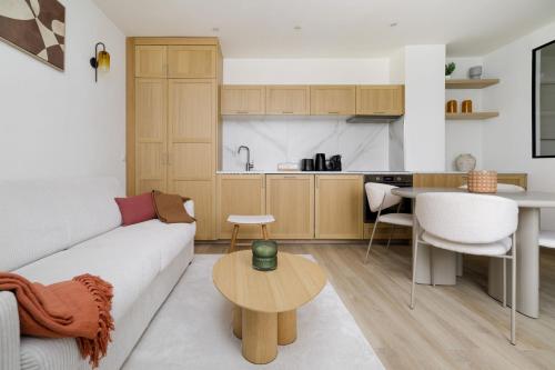 un salon et une cuisine avec un canapé et une table dans l'établissement Modern apartment next to Saint Germain 4PAX, à Paris