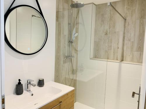 une salle de bain avec une douche avec un lavabo et un miroir dans l'établissement Le Saint Claude, refait a neuf, à La Rochelle