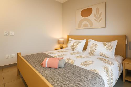 a bedroom with a bed with a pink bag on it at Modern Apt - Direct Pool Access - Beaches 2 min in Mont Choisy