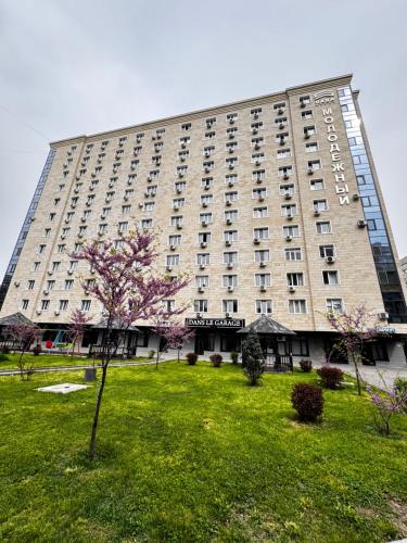 a large building with a park in front of it at Great Cozy Apt in the heart of the city TU116 in Almaty